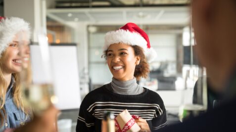 a woman wearing a santa hat holding a present