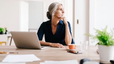 a woman sitting at a table with a laptop