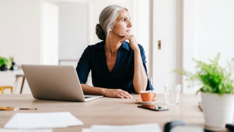 a woman sitting at a table with a laptop