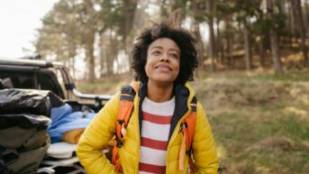 a woman standing in front of a parked car