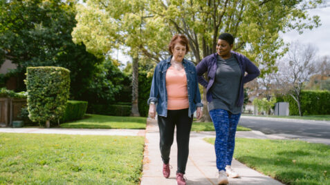 a couple of women walking down a sidewalk