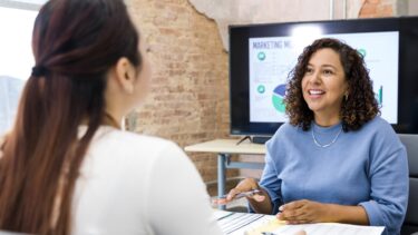 a woman sitting at a table with a cell phone