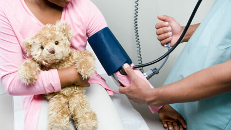 a woman is holding a teddy bear and a stethoscope