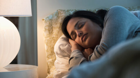 a woman is sleeping in bed with her head on the pillow