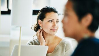a woman sitting in front of a laptop computer