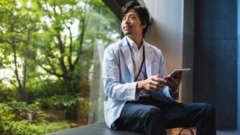 a man sitting on a ledge looking at something