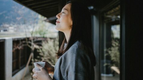 a woman standing outside with her eyes closed