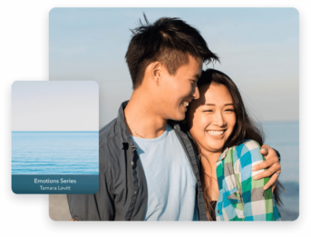 two people standing next to each other near the ocean