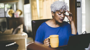 a woman sitting at a table with a cup in front of her