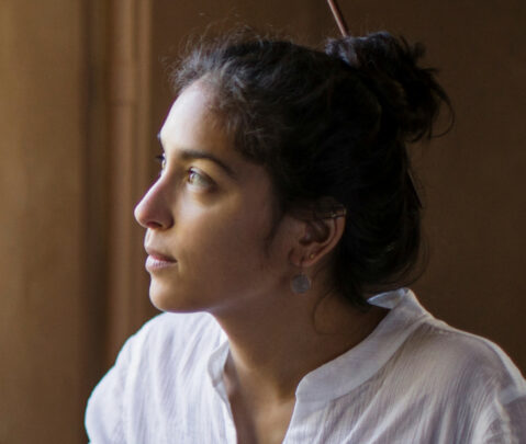 a woman sitting down and looking off into the distance