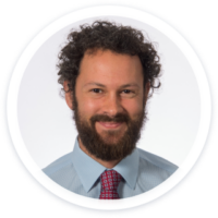 a man with a beard wearing a blue shirt and tie