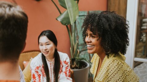 two women sitting at a table talking to each other