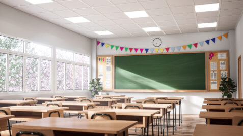 a classroom with desks and a chalk board
