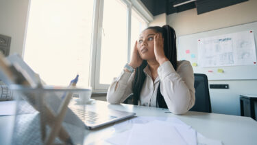 a woman sitting at a desk in front of a laptop computer