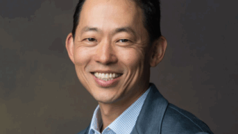 a man in a suit smiling at the camera