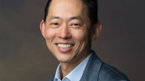 a man in a suit smiling at the camera