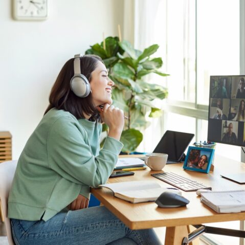 a woman sitting at a desk with headphones on