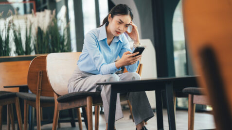 Gen Z woman on phone reading negative news