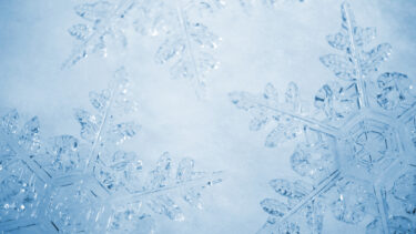 a close up of a snowflake on a blue background