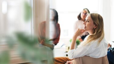 a woman sitting in a chair in front of a mirror
