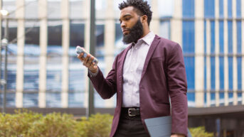 a man in a suit and tie is looking at his cell phone