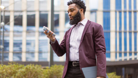 a man in a suit and tie is looking at his cell phone